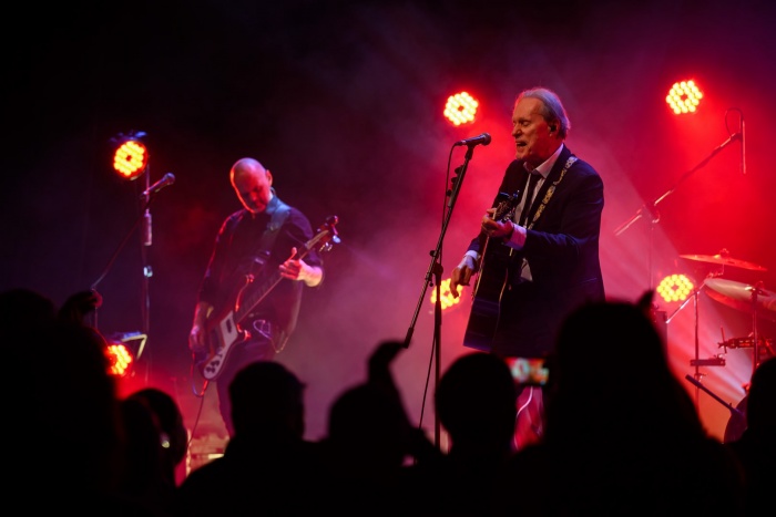 Koncert: John Porter - Helicopters'45 - Na scenie grający na gitarze i śpiewający John Porter, w tle grający na basie Jacek Szafraniec